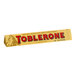 A yellow Toblerone milk chocolate candy bar with red and blue text.