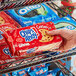 A hand holding a package of Nabisco Chips Ahoy! Chewy Chocolate Chip Cookies.
