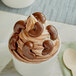 A cup of ice cream with Albanese milk chocolate covered cashews on top.