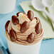 A cup of ice cream with milk chocolate covered almonds.