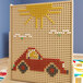 A Flash Furniture peg board with multi-color pegs, a car and sun on it.