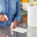 A woman using a Bounty paper towel to clean a counter.