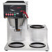 A Grindmaster automatic coffee brewer with three warmers on a counter.