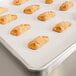 A Baker's Lane parchment paper sheet with a tray of pastries on a counter.