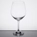 A close-up of a clear Stolzle Burgundy wine glass on a reflective surface.