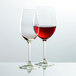 Two Stolzle chardonnay wine glasses filled with red wine.