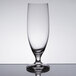 A close-up of a clear Stolzle stemmed beer glass on a table.