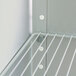 A close-up of a white metal shelf with white shelf support pins.