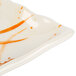 A close up of a white rectangular melamine wave plate with an orange and white swirl design.