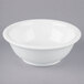 A Tuxton white china footed salad bowl on a gray surface.