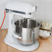 A white KitchenAid bowl lift mixer with a bowl of eggs in it.