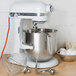 A white KitchenAid bowl lift countertop mixer with whisk attachments mixing eggs in a bowl.