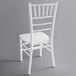 A white Lancaster Table & Seating chiavari chair with a wooden seat.