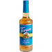 A Torani Sugar-Free Salted Caramel flavoring syrup in a glass bottle with a blue label.