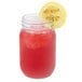 A Libbey mason jar filled with red liquid and a lemon slice on the rim.