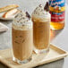 Two glasses of iced coffee with whipped cream and chocolate chips made with Torani Sugar-Free Almond Roca Flavoring Syrup.