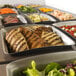A close-up of food in a Vollrath stainless steel food pan.