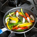 A Vollrath Wear-Ever fry pan filled with cooking peppers and onions.