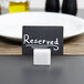 An American Metalcraft white marble table card holder with a black reserved sign.
