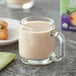 A glass mug of Oregon Chai Organic Caffeine Free Chai Tea Latte next to a bottle of Oregon Chai concentrate.
