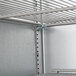 A metal shelf with metal rods inside a Beverage-Air back bar refrigerator.