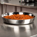 An American Metalcraft Mesa food pan with red sauce inside on a counter.