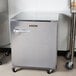 A Traulsen undercounter refrigerator with a right hinged door and stainless steel back and a handle.