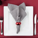 A 10 Strawberry Street white porcelain charger plate with silverware and a red napkin on it.