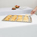 A Tablecraft Remington stainless steel tray holding croissants on a table.