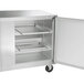 A silver stainless steel Traulsen undercounter freezer with left and right hinged doors open.