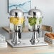 An Acopa stainless steel and polycarbonate double beverage dispenser with lemons and limes.