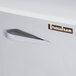 The right hinged door handle on a Traulsen stainless steel refrigerator.