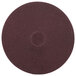 A maroon circular Scrubble floor pad with a hole in the middle.