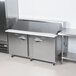 A Traulsen stainless steel refrigerated sandwich prep table with left and right hinged doors.