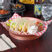 A table with a round deli server holding tacos and salsa.