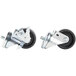 A close-up of two black and white swivel casters for a Traulsen refrigerator.