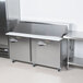 A Traulsen stainless steel sandwich prep table with two right hinged doors.