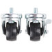 A pair of Traulsen stem casters with black rubber wheels and metal frames.