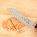 A Mercer Renaissance knife cutting meat on a cutting board.