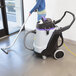 A woman using a ProTeam vacuum to clean a room.