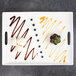A white rectangular porcelain platter with desserts on it and handles.