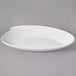 A white oval shaped bowl with a curved edge.