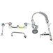 A T&S chrome wall mounted pre-rinse faucet with hose and hand shower parts.
