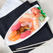 A 10 Strawberry Street white porcelain sushi boat with sushi on a white plate.