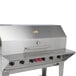 A stainless steel barbecue grill with a removable front shelf.