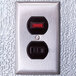 A metal wall switch with red and black numbers.