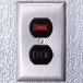 A metal wall switch with red and black numbers inside a walk-in cooler.