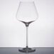 A Stolzle Quatrophil Burgundy wine glass with a clear rim on a table.