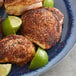 A plate with three chicken breasts sprinkled with Regal Chipotle Powder and lime wedges.