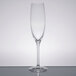 A clear Stolzle flute glass with a single stem on a table.